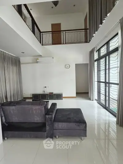 Spacious modern living room with high ceiling and large windows