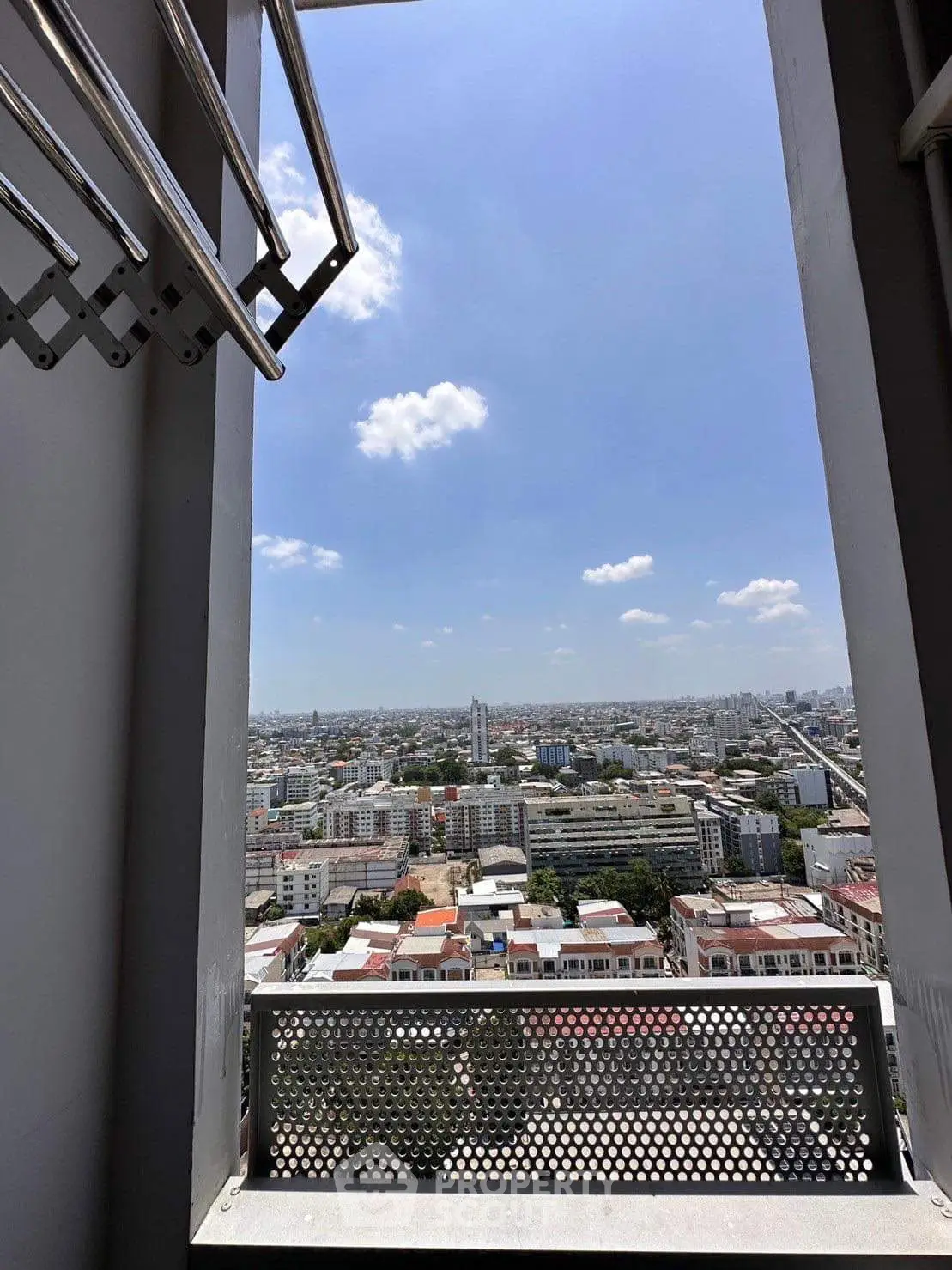 Stunning cityscape view from high-rise balcony on a clear day.