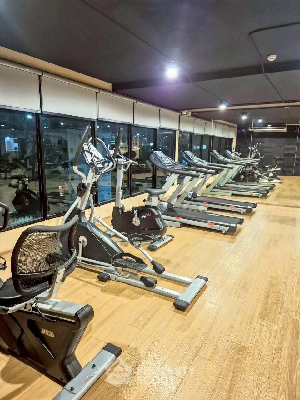 Spacious modern gym with state-of-the-art fitness equipment and large windows.