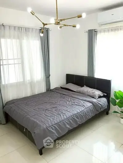 Modern bedroom with stylish lighting and large windows in a bright apartment.