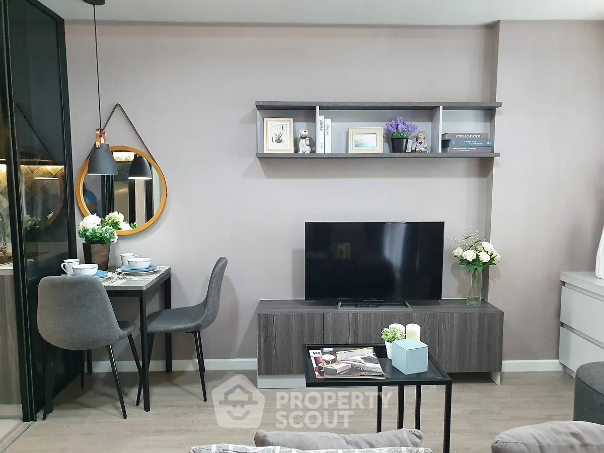 Modern living room with stylish decor, TV unit, and cozy dining area in a contemporary apartment.