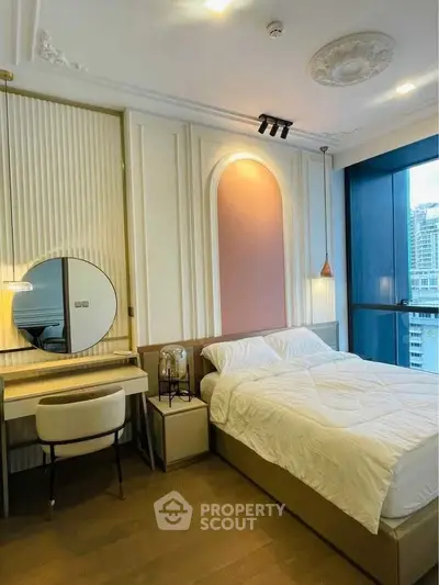 Luxurious bedroom with elegant decor and city view, featuring a stylish vanity and modern lighting.