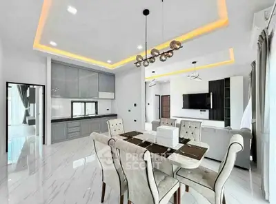 Luxurious open-plan living and dining area with modern kitchen and elegant lighting.