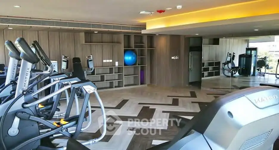 Spacious modern gym with state-of-the-art equipment and stylish flooring