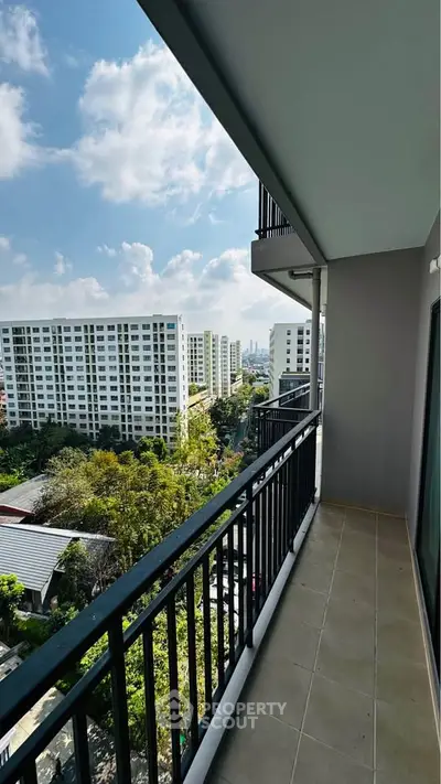Spacious balcony with stunning city view in modern apartment building.