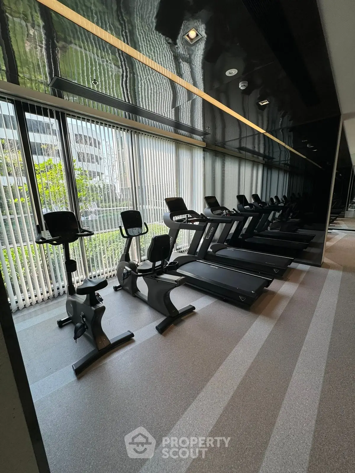 Modern gym with treadmills and exercise bikes in a sleek building