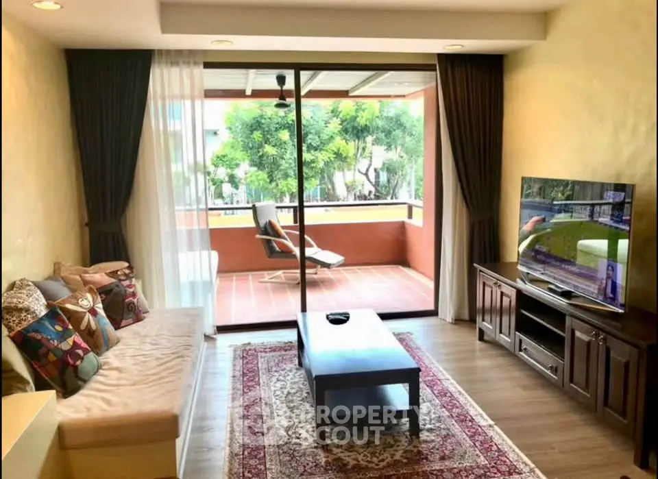 Charming living room with large balcony and modern decor, perfect for relaxation and entertainment.