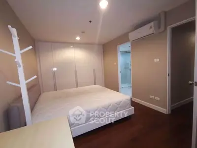 Spacious bedroom with modern design and ample storage in a stylish apartment.