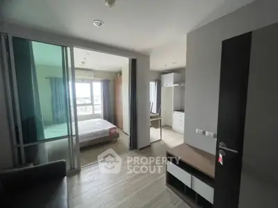 Modern apartment interior with bedroom and living area, featuring sleek design and natural light.