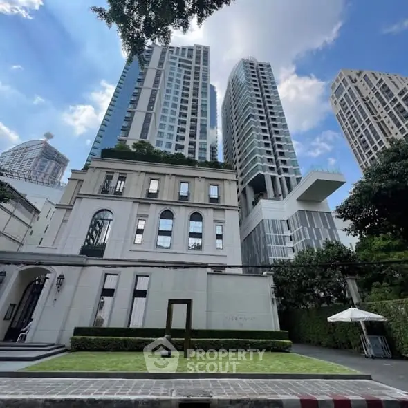 Stunning modern high-rise buildings with lush greenery and clear blue sky.
