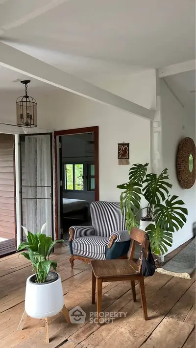 Charming interior with cozy armchair and lush plants in a bright room.