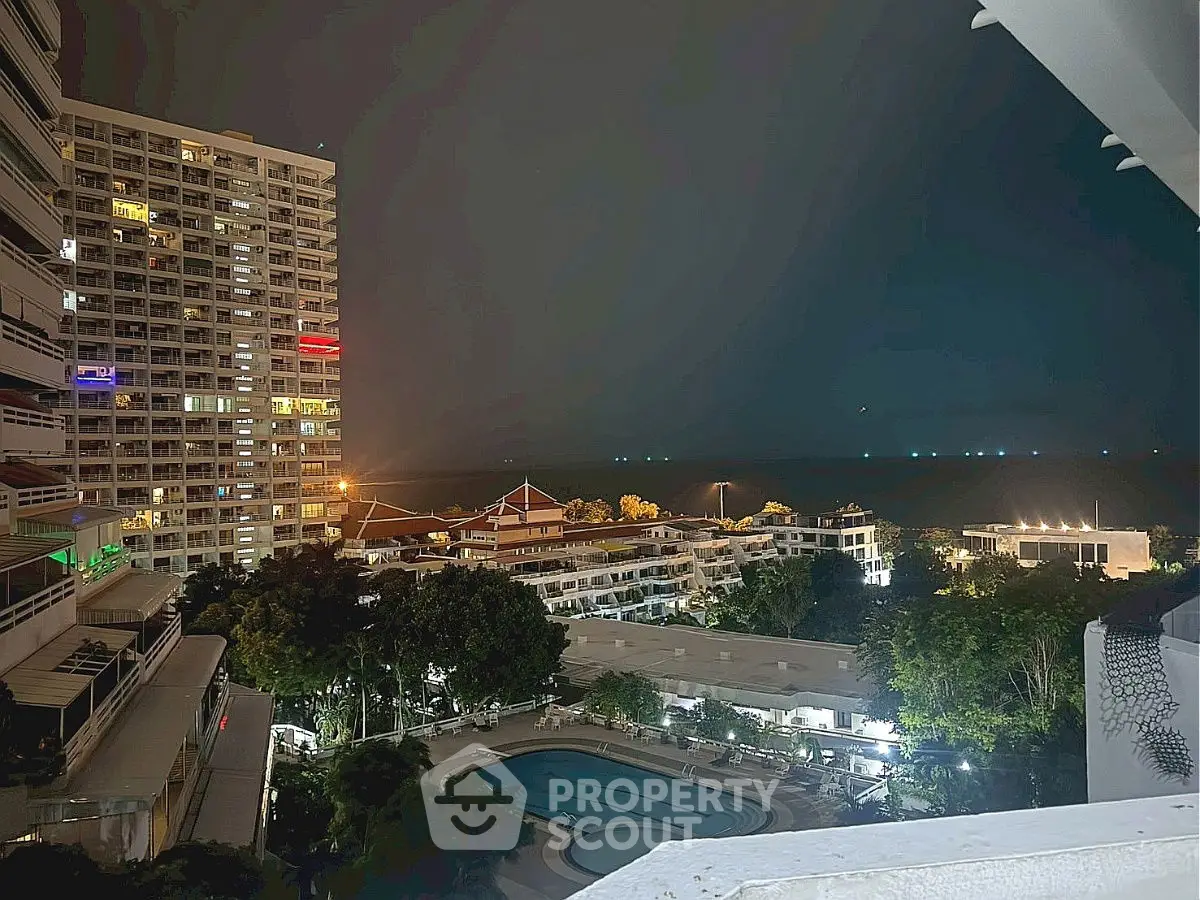 Stunning night view of a residential complex with a pool and city lights.