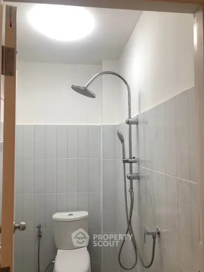Compact bathroom with modern shower and toilet in minimalist design.
