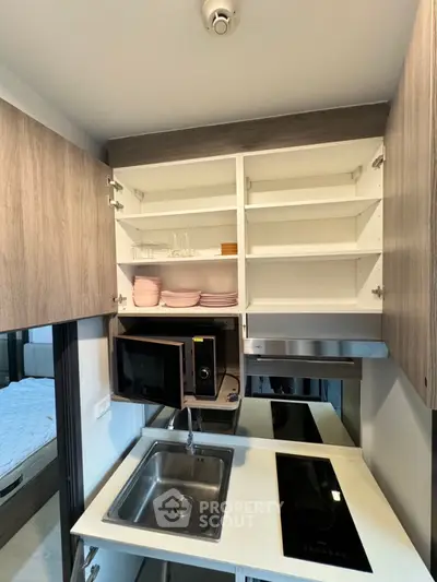 Modern compact kitchen with open cabinets and sleek appliances