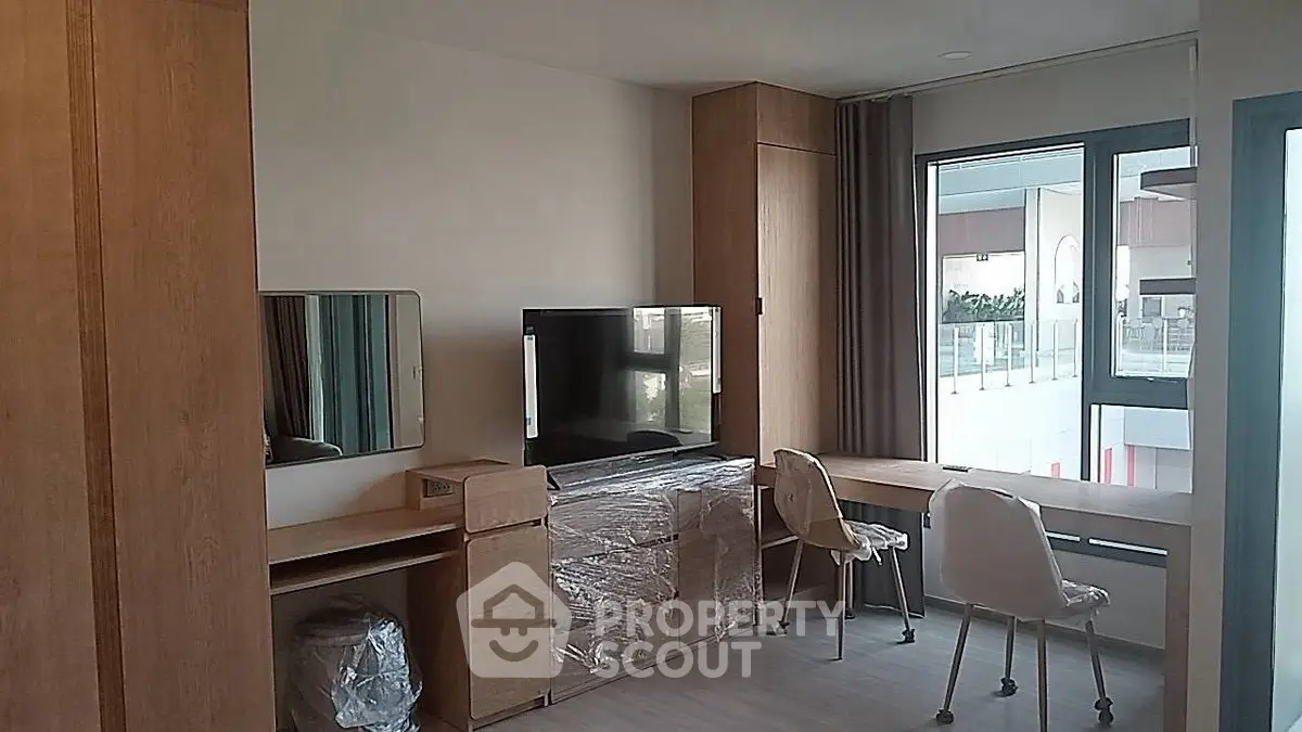 Modern furnished living room with TV and large window view