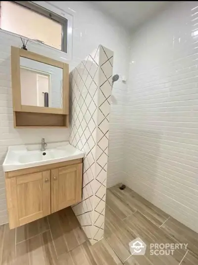 Modern bathroom with stylish wooden vanity and tiled shower area