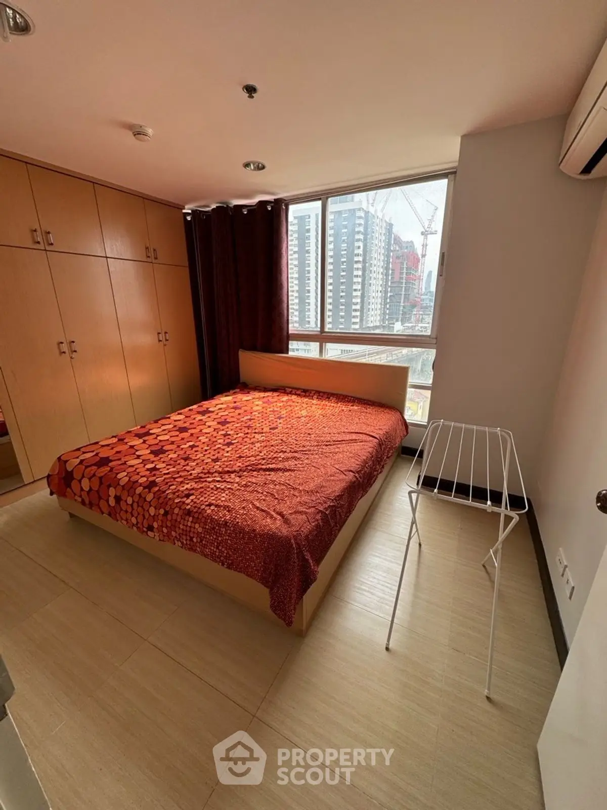Cozy bedroom with city view and ample storage in modern apartment.