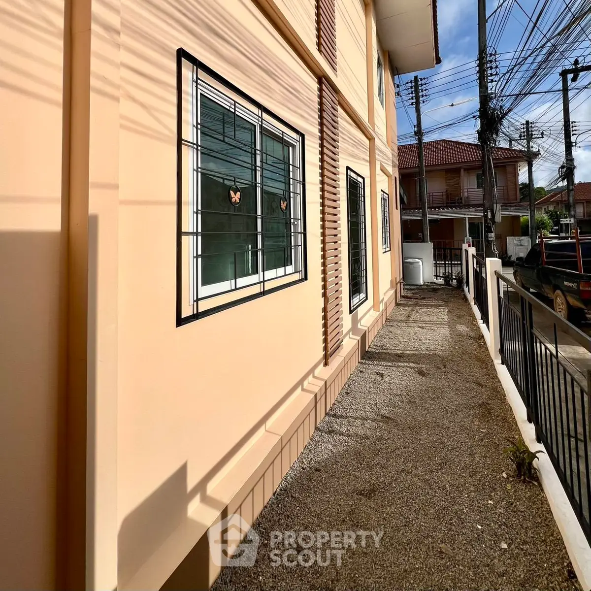 Exterior view of a residential building with windows and a paved walkway, showcasing urban living.