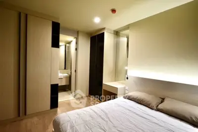 Modern bedroom with sleek design and ensuite bathroom in a stylish apartment.