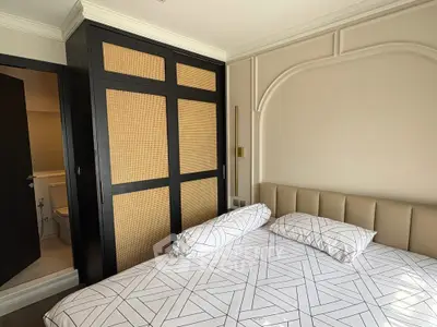 Modern bedroom with stylish geometric bedding and built-in wardrobe
