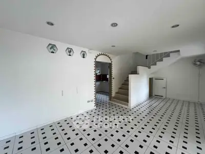 Spacious modern living room with unique tile flooring and staircase