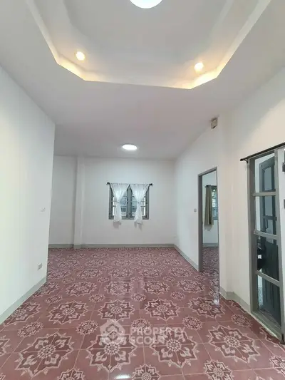 Spacious living room with unique patterned flooring and recessed lighting