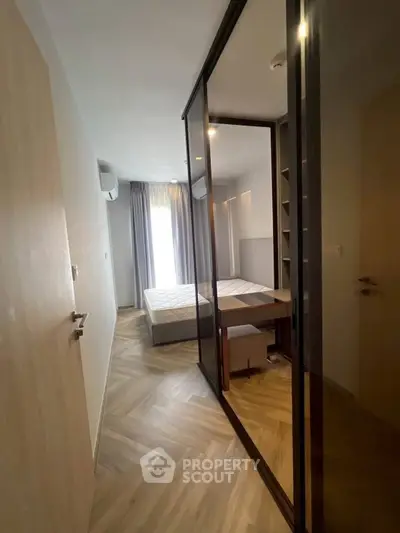 Modern bedroom with stylish herringbone flooring and mirrored closet doors