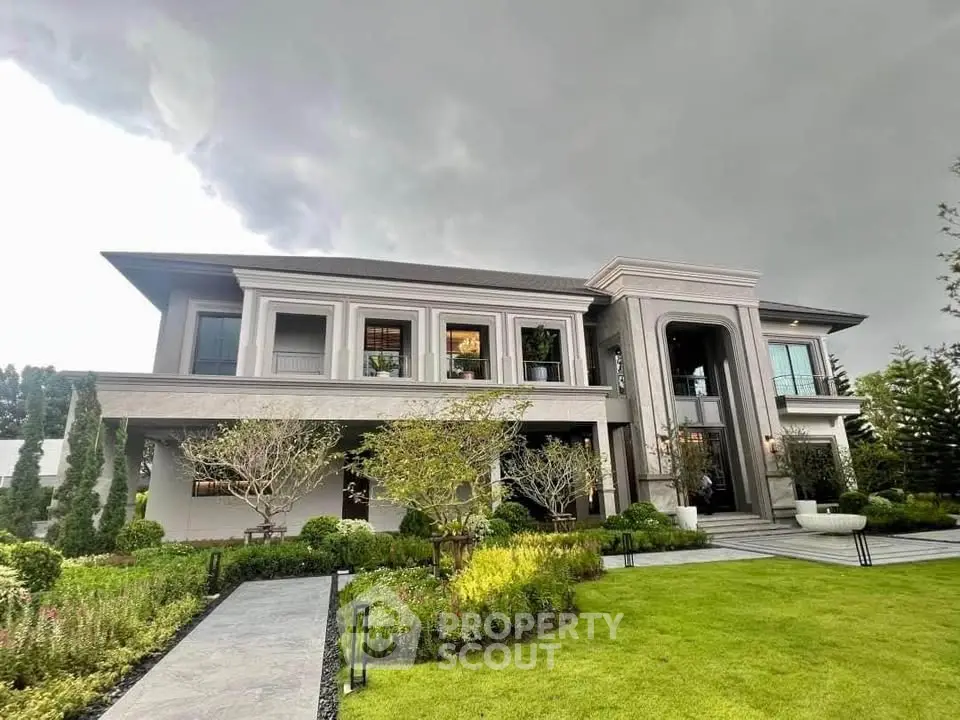 Luxurious modern mansion with lush garden and dramatic sky
