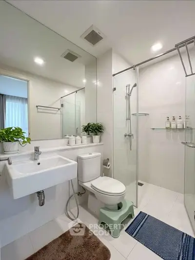 Modern bathroom with glass shower, sleek fixtures, and elegant decor in a contemporary home.