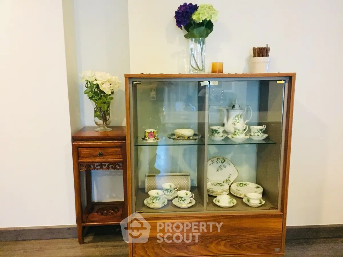 Elegant interior with vintage china cabinet and floral decor, perfect for cozy home ambiance.