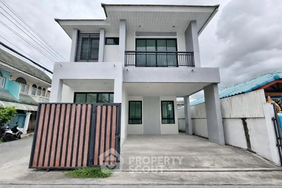 Modern two-story house with sleek design and spacious driveway in a suburban neighborhood.