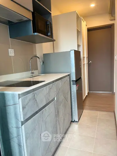 Modern compact kitchen with sleek cabinetry and stainless steel appliances