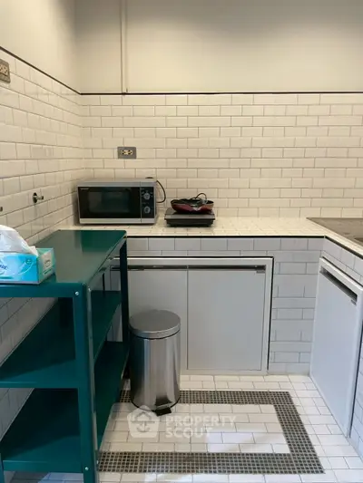 Compact kitchen with white subway tiles and modern appliances