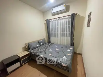 Cozy bedroom with modern decor and air conditioning, perfect for relaxation.