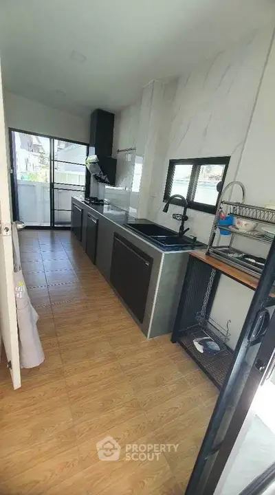 Modern kitchen with sleek cabinetry and open layout, featuring a gas stove and ample natural light.