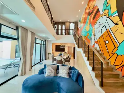 Spacious modern living room with vibrant wall art and elegant blue sofa