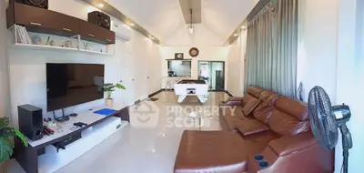 Spacious living room with modern entertainment setup and pool table, perfect for relaxation and gatherings.