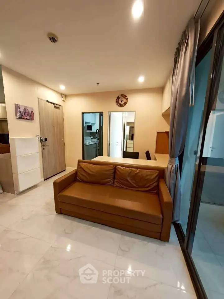 Modern living room with brown leather sofa and marble flooring in a stylish apartment.