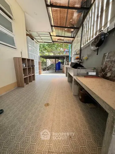 Spacious outdoor kitchen area with tiled flooring and natural light, perfect for entertaining.