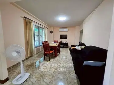 Spacious living room with dining area, featuring marble floors and modern furnishings.