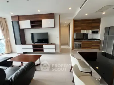 Modern living room with sleek furniture and open kitchen layout in a stylish apartment.