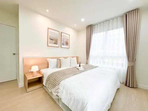 Bright and cozy bedroom with modern decor and large window for natural light.