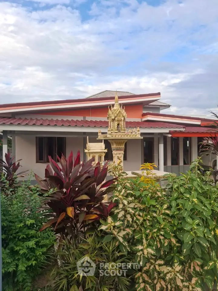 Charming single-story home with lush garden and traditional decorative features.
