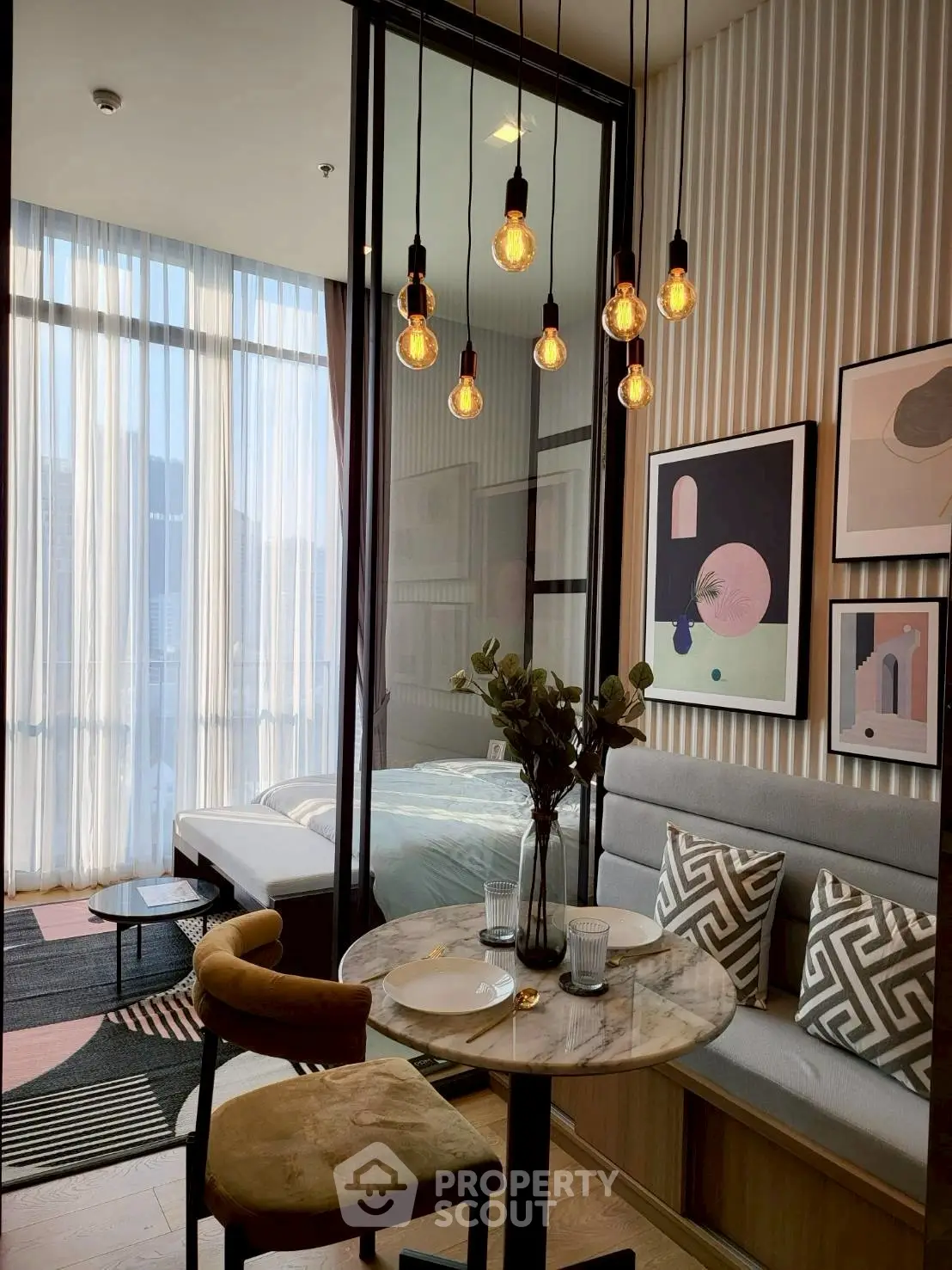 Modern studio apartment with stylish dining area and cozy bedroom, featuring elegant lighting and contemporary decor.