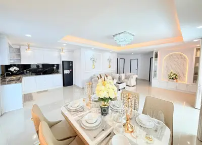 Luxurious open-plan living room and kitchen with elegant dining setup and modern decor.