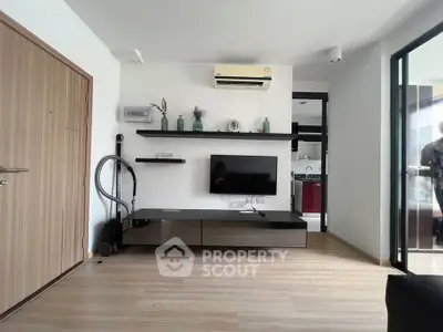 Modern living room with sleek TV unit and air conditioning in a stylish apartment.