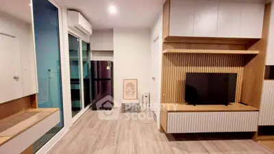 Modern living room with sleek wooden cabinetry and large glass doors leading to balcony.