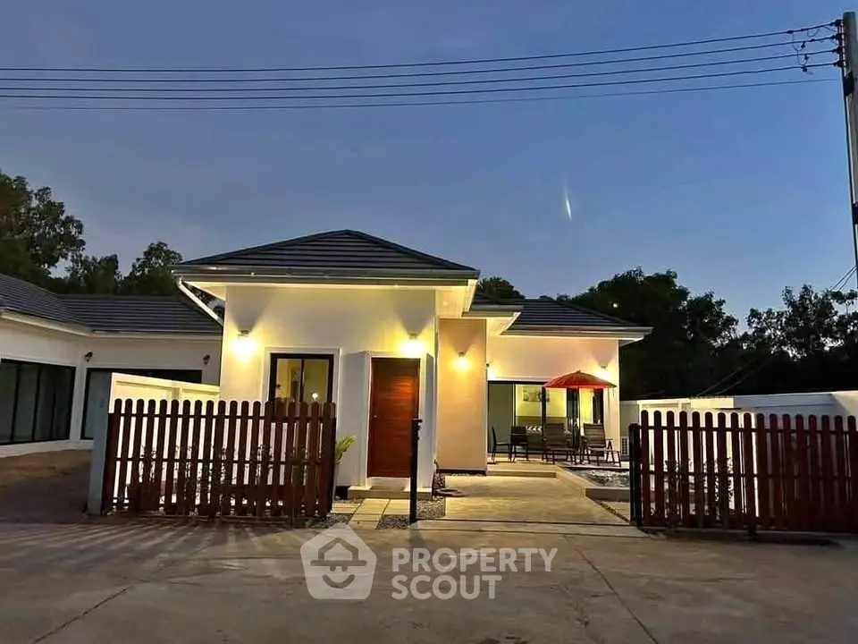 Charming modern house with inviting exterior lighting and spacious patio area.