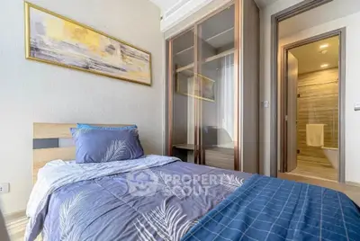 Cozy bedroom with modern decor and ensuite bathroom in stylish apartment.
