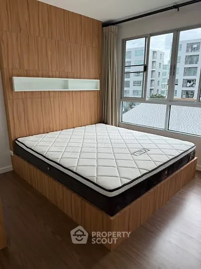 Modern bedroom with wooden accents and large window offering natural light